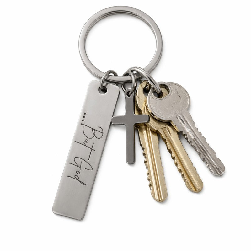 My Giving Store stainless steel keychain with engraved "...But God" pendant and cross charm, holding keys.