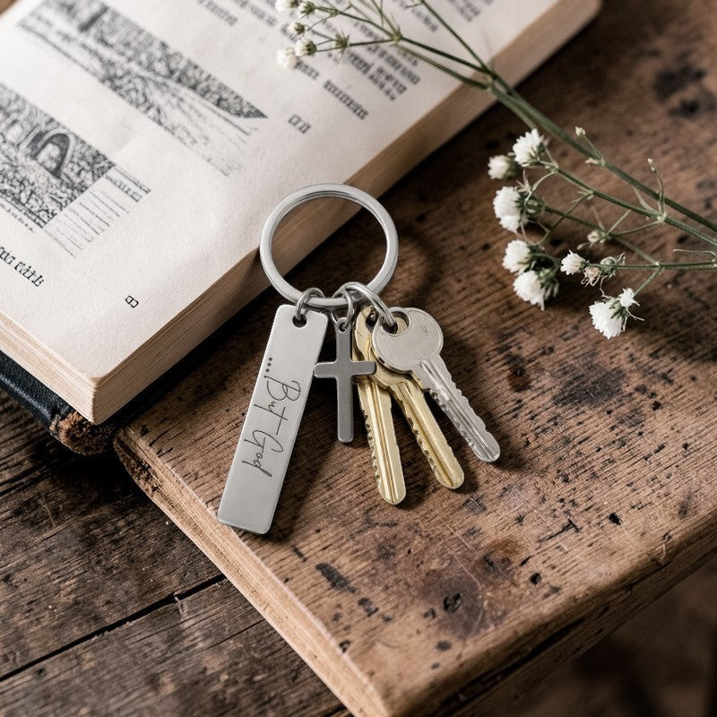 My Giving Store stainless steel keychain with engraved "...But God" pendant and cross charm.