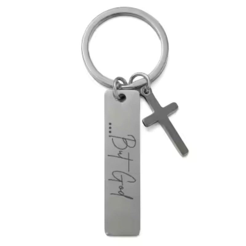 My Giving Store stainless steel keychain with a vertical bar pendant engraved with "...But God" and a dangling cross charm.